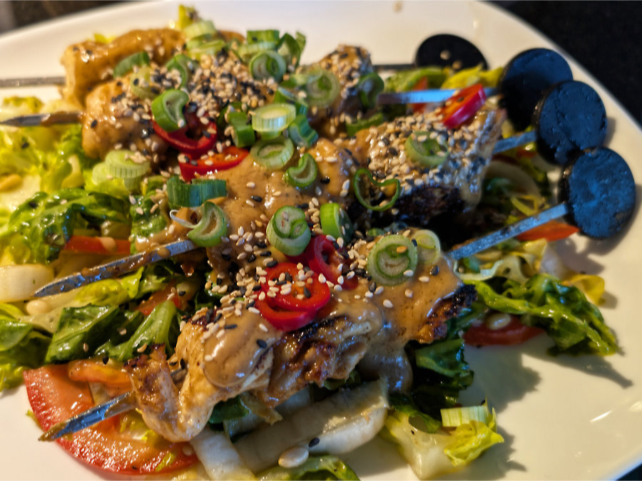 Saté-Spießchen auf Salat